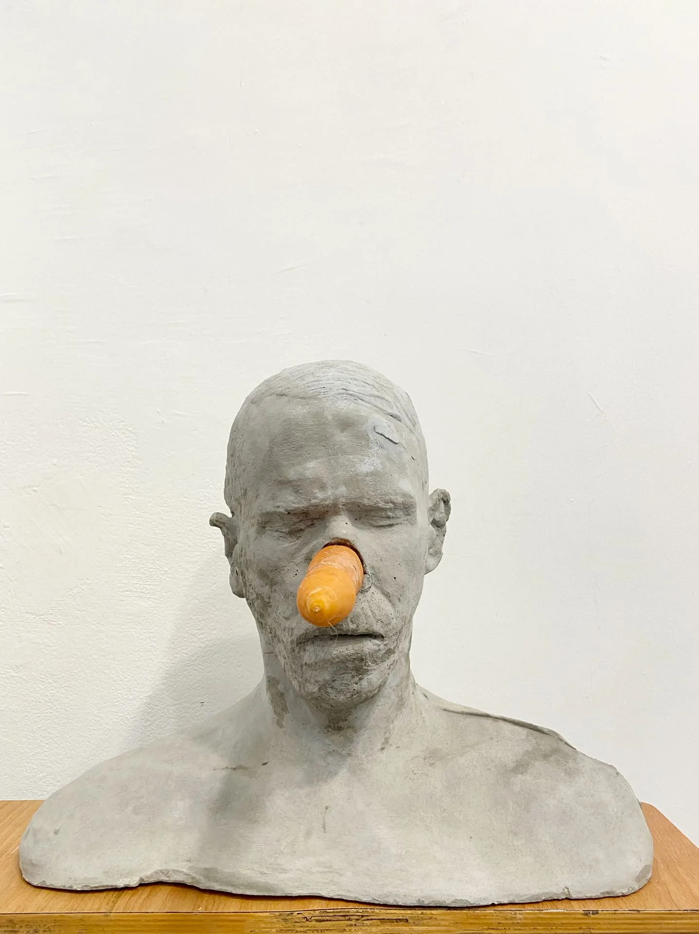 Erez Israeli, Cain (self-portrait), 2015, concrete casting, fresh carrot, coat rack, ceramic pig head
