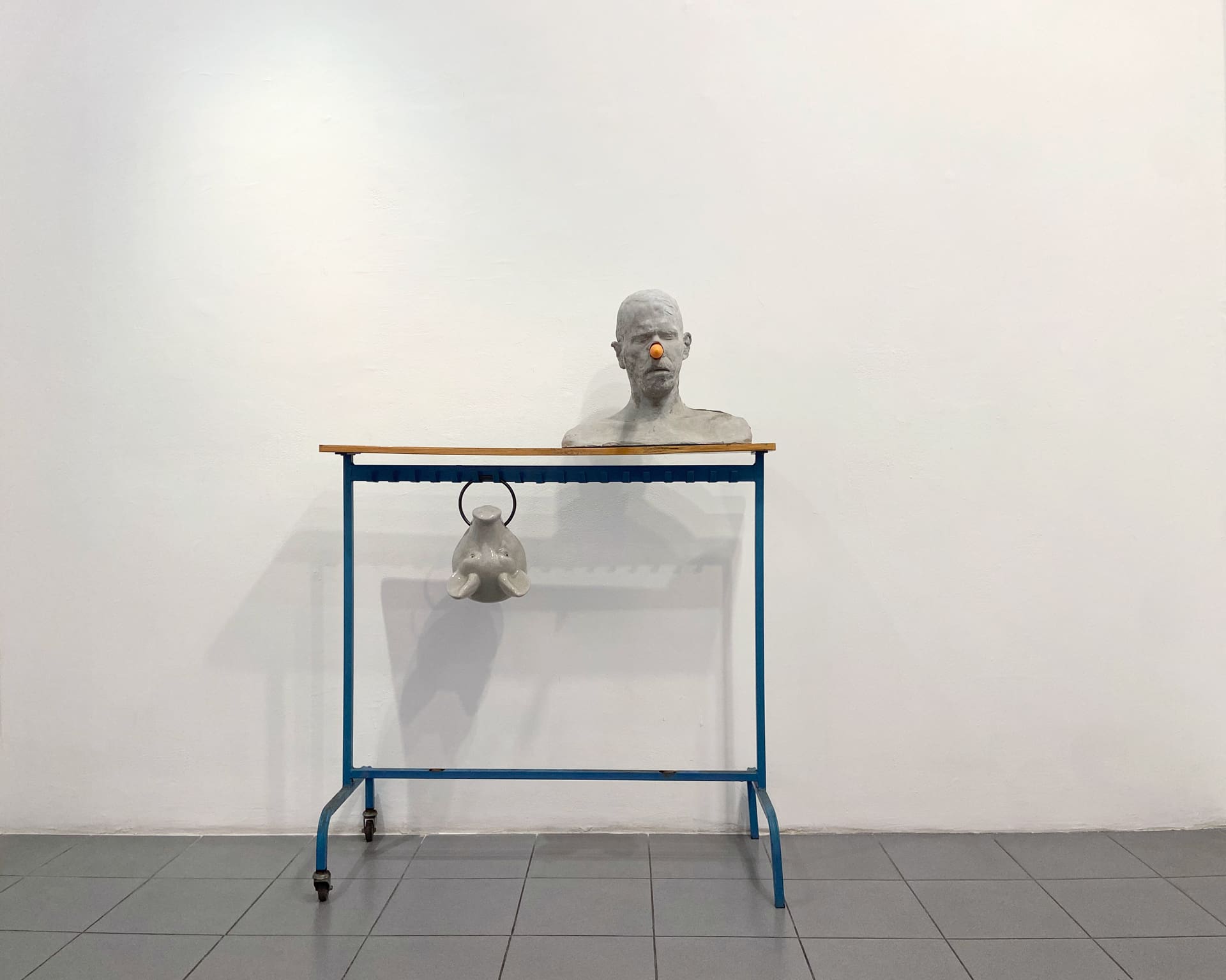 Erez Israeli, Cain (self-portrait), 2015, concrete casting, fresh carrot, coat rack, ceramic pig head