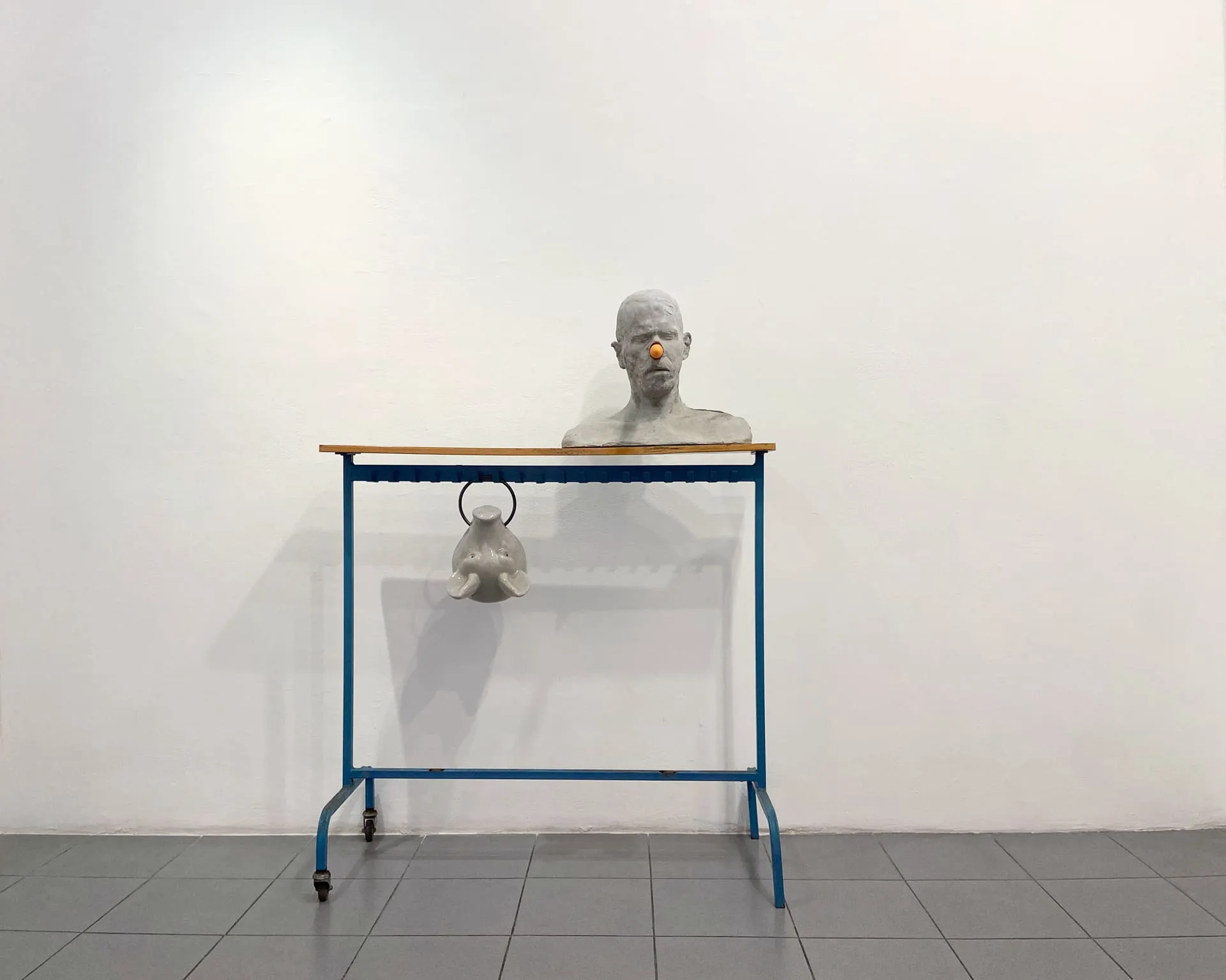Erez Israeli, Cain (self-portrait), 2015, concrete casting, fresh carrot, coat rack, ceramic pig head